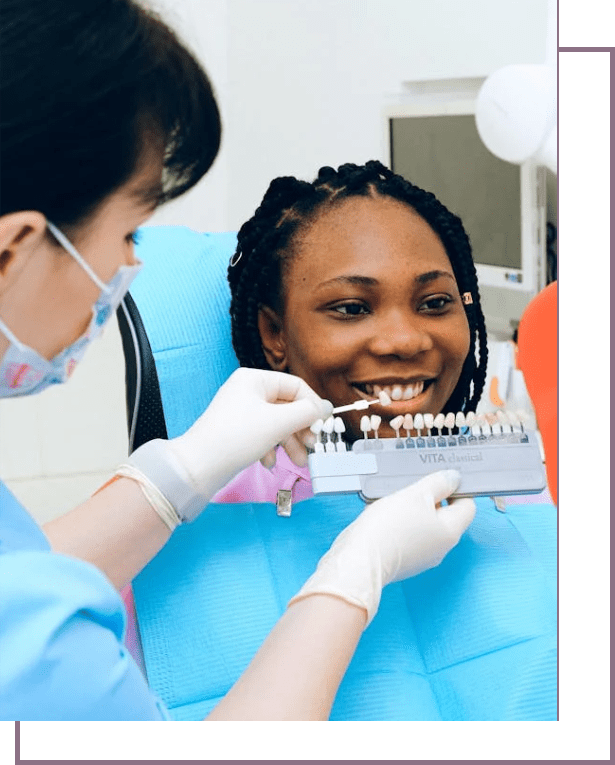 A dentist is showing a patient how to brush her teeth.