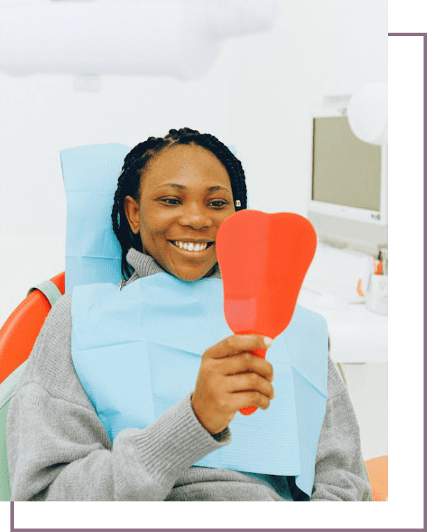 A woman sitting in the dentist chair holding an object.